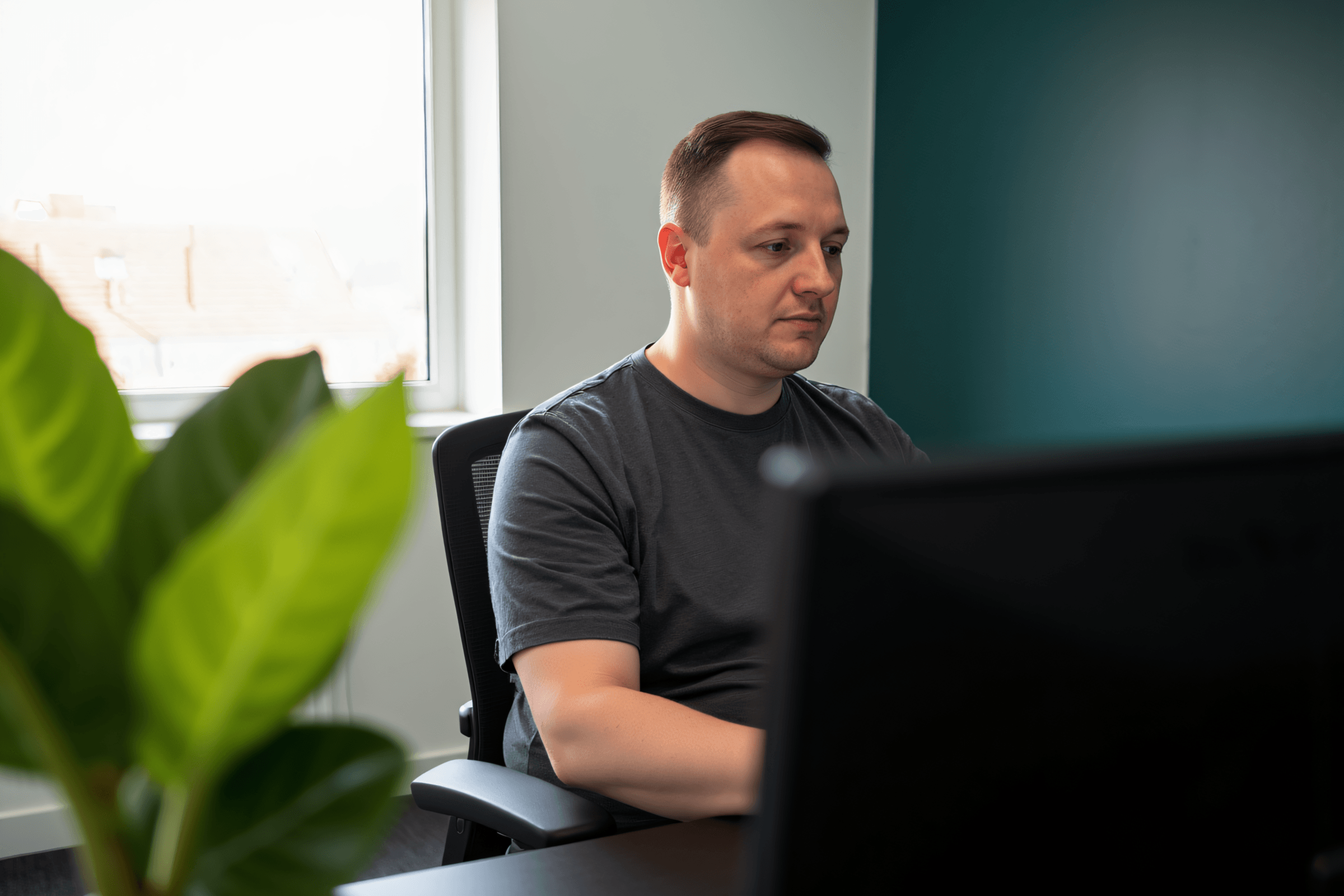 Joe, founder of Wayfind Studio, working at his desk in the studio office
